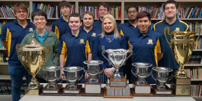 GM Priyadharshan Kannappan founder of Chess Gaja with his Webster University Teammates and coach GM Susan Polgar with the trophies won by the team
