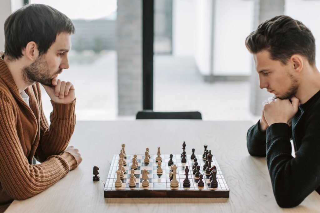 Two competitive chess players facing each other across a board, both in deep concentration