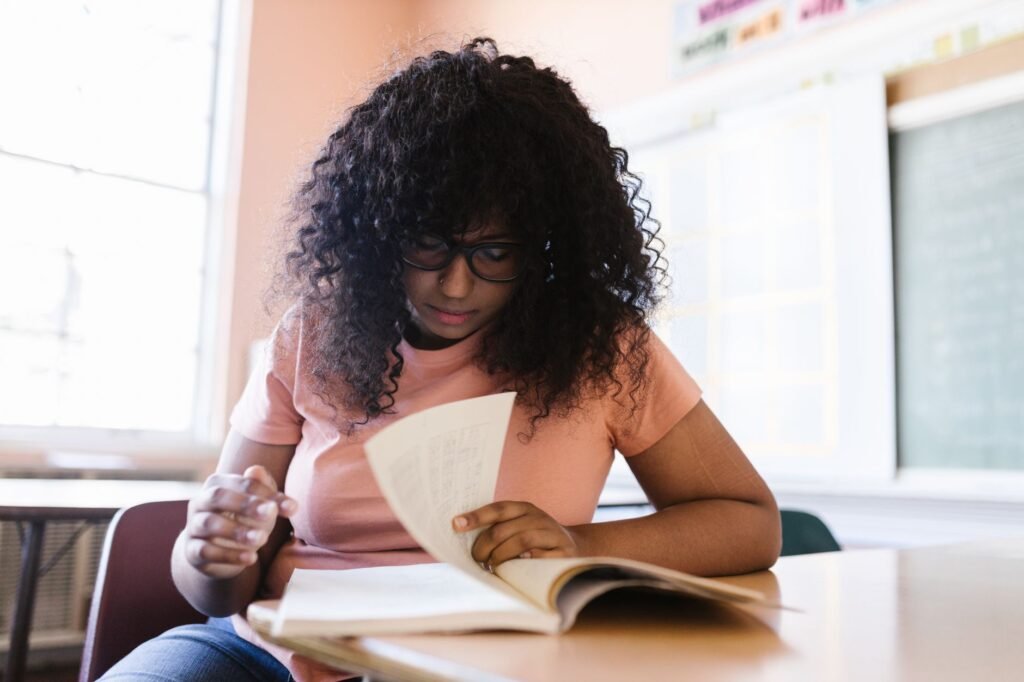 A young student studying from a book at a desk, representing a structured chess opening study plan