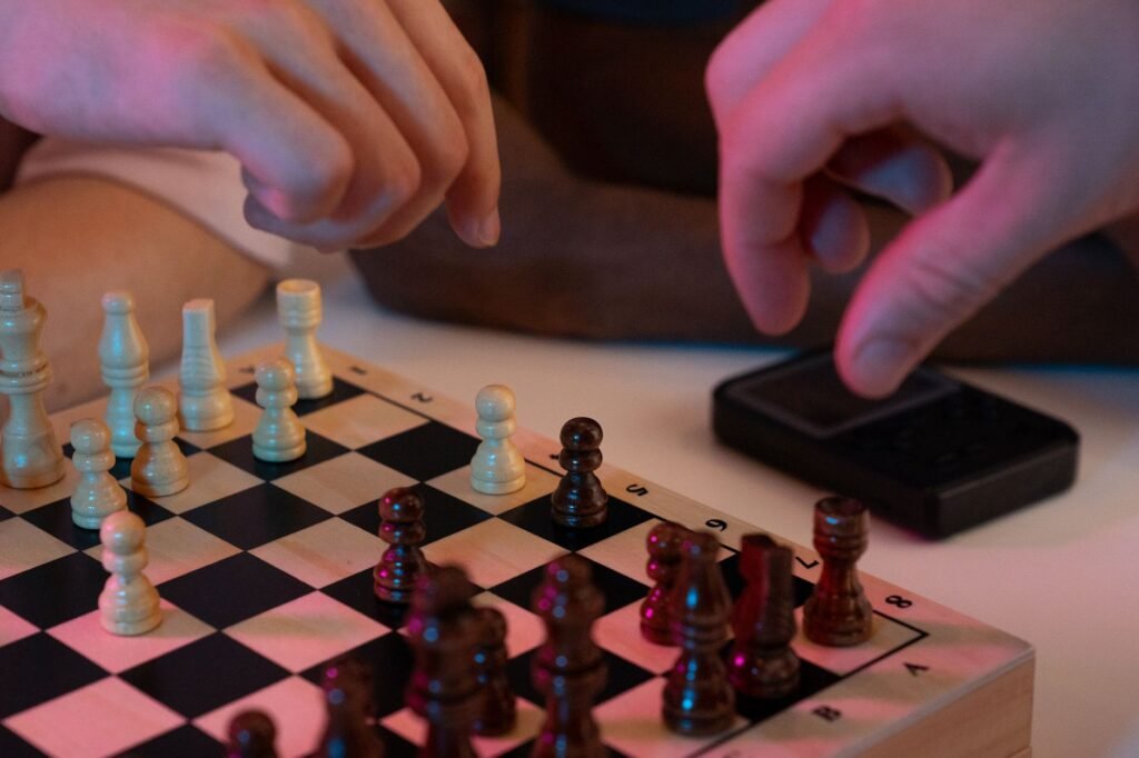 Hands moving a chess piece during a game with a clock visible, capturing an in-game decision moment