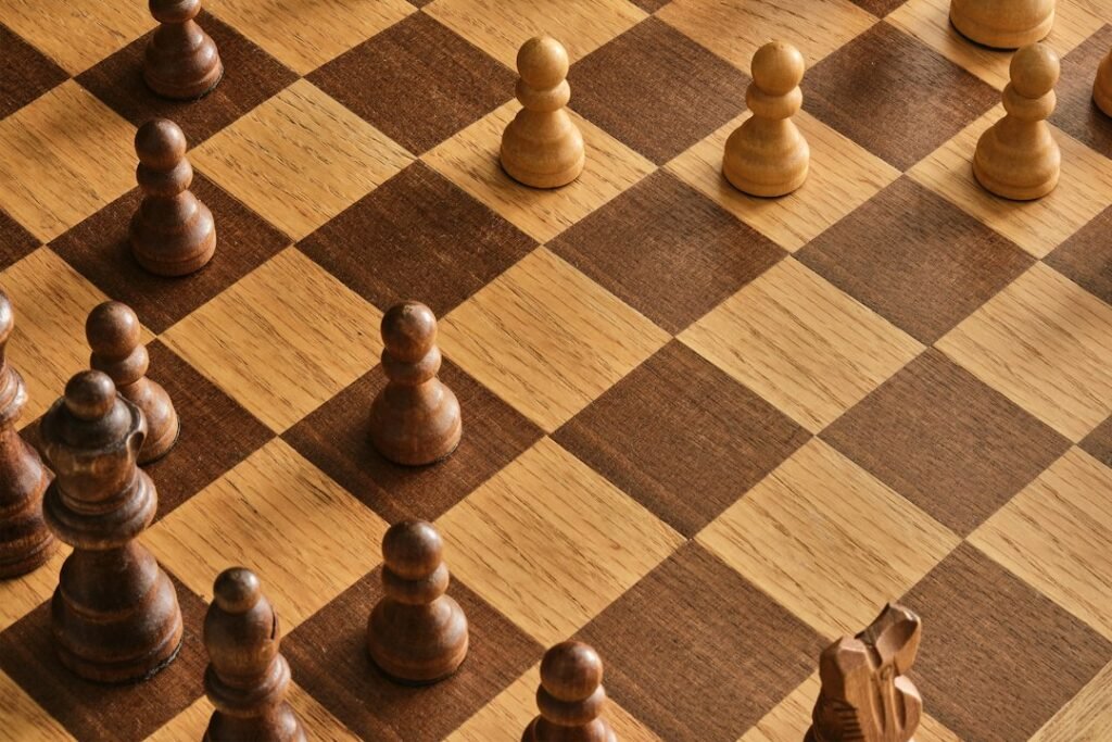 Close-up aerial view of a wooden chess board showing pawns and pieces in an endgame structure, illustrating the endgame conversion techniques covered in Fix 5.