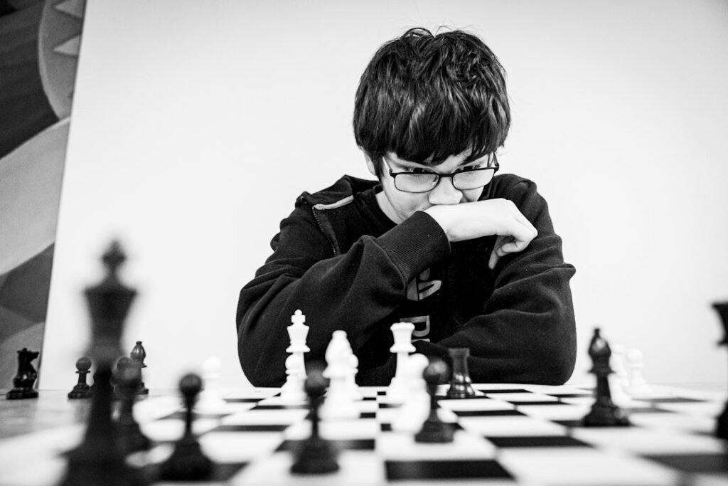 Young boy in deep concentration studying a chess board during serious training