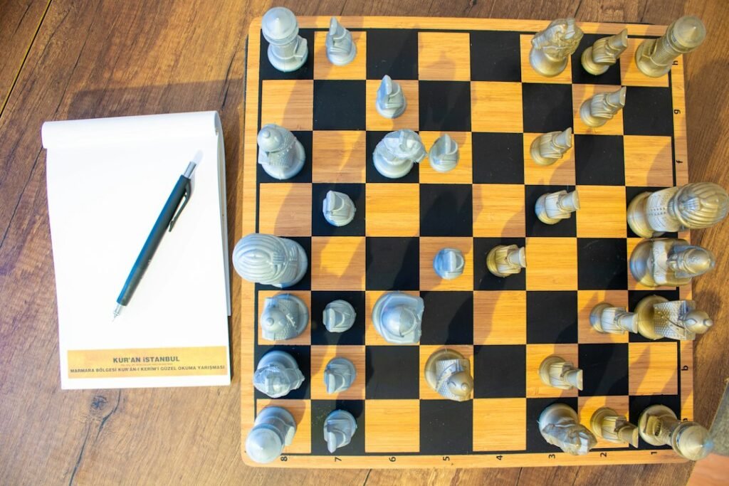 Chess board with notepad and pen beside it for writing down move analysis during tactics study