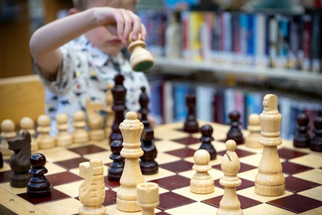 Young child moving a chess piece during a beginner training session